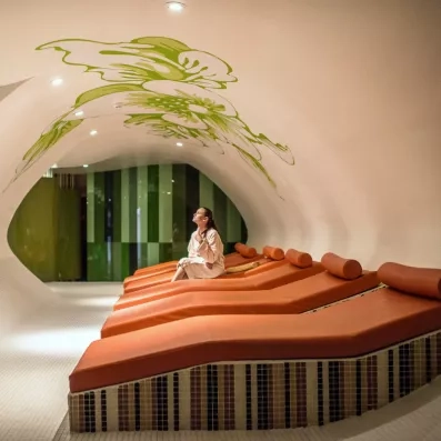 Un espace de relaxation avec des banquettes orange au design organique.