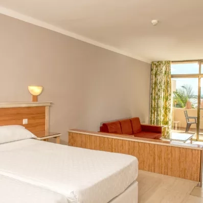 Une chambre climatisée offrant un accès direct à un balcon privé pour profiter de la brise marine.