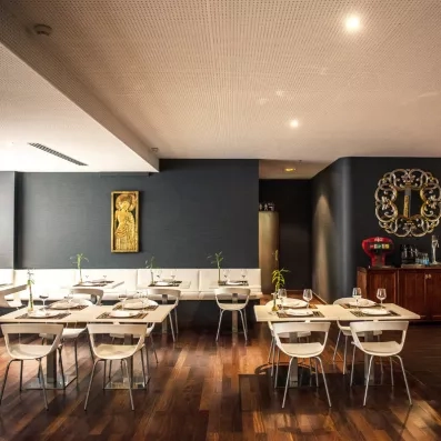 Une salle de restaurant élégante et moderne, décorée de cadres dorés et de tables dressées.