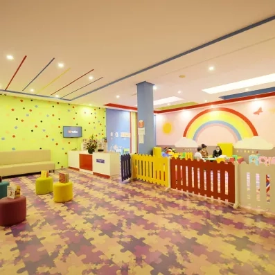 mini club pour enfants avec un arc en ciel peint sur le mur et un parc de jeux jeux