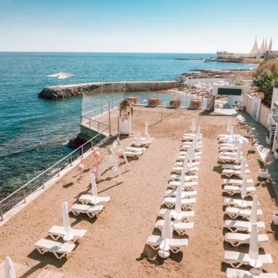 plage avec transats et parasols vue face à la mer