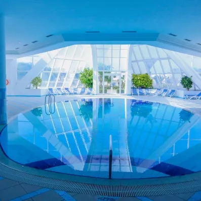 Vue panoramique de la piscine couverte avec transats de relaxation au complexe Al Jazira à Djerba.