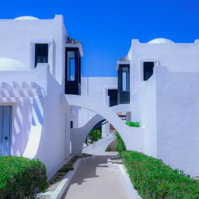 Architecture traditionnelle blanche avec arches et coupoles sous le ciel bleu de l'hôtel Al Jazira Djerba.