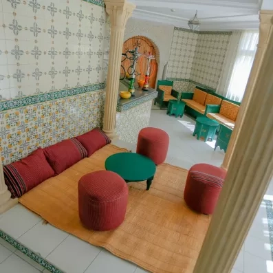 Salon traditionnel tunisien avec mosaïques typiques et chichas pour une immersion culturelle à Djerba.