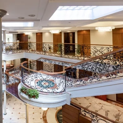 Hall d'entrée majestueux avec escalier en fer forgé et sol marbré d'un navire de croisière.