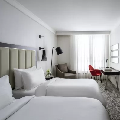 chambre avec deux lits simples et un bureau