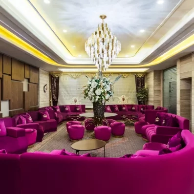 Hall d’entrée avec coin salon composé de canapés et de fauteuils roses