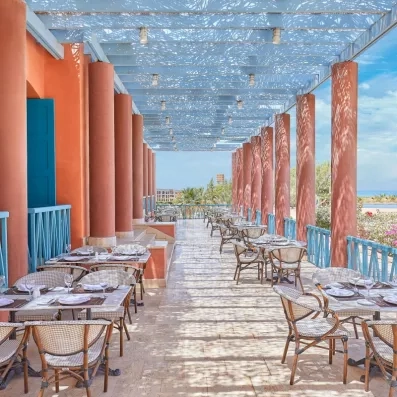 Terrasse ombragée avec vue mer, petit-déjeuner en plein air au resort de luxe en Égypte.