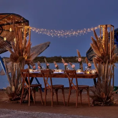 Table dressée sur la plage au coucher du soleil, dîner privé exclusif à Hurghada.