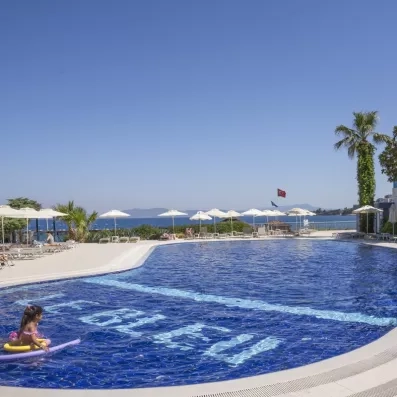 Une grande et belle piscine d'hôtel avec des chaises longues et des parasols.