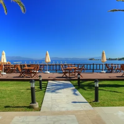 Une terrasse en bois face à l'horizon, aménagée de tables et de parasols.