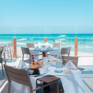 Déjeuner en terrasse face à la mer turquoise de Djerba au restaurant de l'hôtel Vincci Dar Midoun.