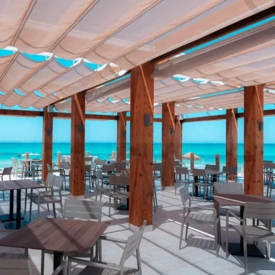 Terrasse ombragée avec vue panoramique sur la plage méditerranéenne du complexe hôtelier Vincci Dar Midoun.