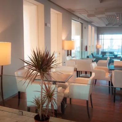 Salon intérieur moderne de l'hôtel Vincci Dar Midoun à Djerba avec fauteuils blancs et plantes vertes.