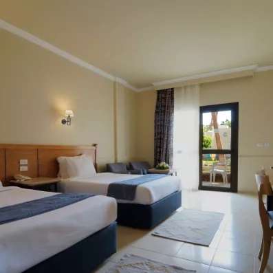 chambre avec 2 lits séparés, tableau décoratif, porte fenêtre menant à la terrasse  