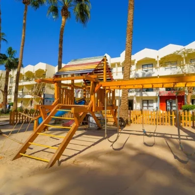 air de jeux pour enfant en bois à l'extérieur de l'hôtel, palmiers, soleil