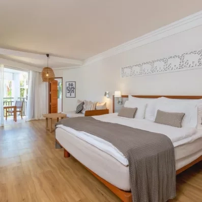 Une chambre spacieuse avec un grand lit double et d'un accès direct à un balcon privé.