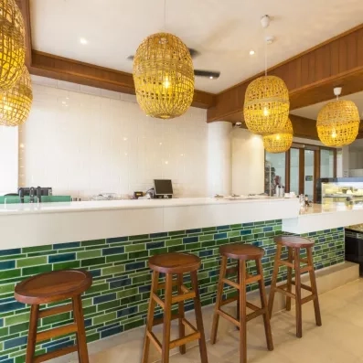 Un bar moderne avec son comptoir orné de carreaux turquoise.