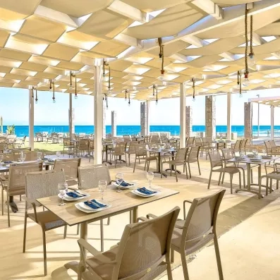 restaurant sur la terrasse extérieur sur la plage, avec des tables et des chaises  