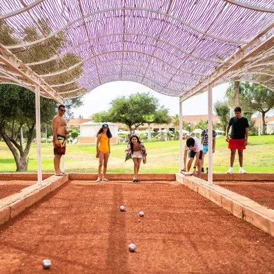 Une famille jouant au pétanque dans la partie loisirs de l'hôtel