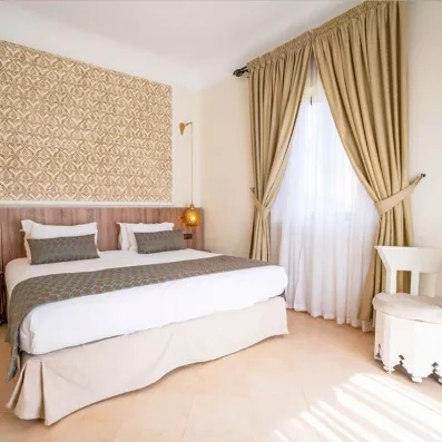 lit double, avec lampadaire suspendus avec une fenêtre décorée de rideaux en voiles blancs et beige 