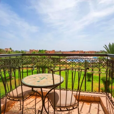 balcon à ciel ouvert avec vue sur le jardin et la piscine au fond