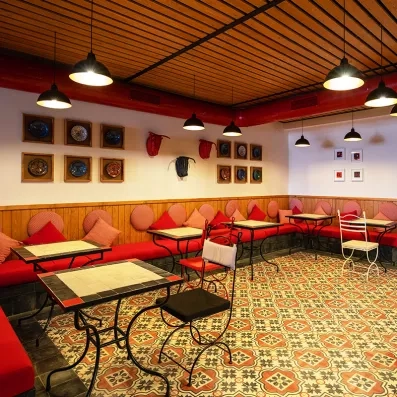 tables et chaises du restaurant à la carte de l'hôtel avec des coussins rouges