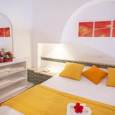 Aménagement intérieur d'une chambre au Seabel Aladin incluant un coin rangement, un grand miroir et un éclairage d'ambiance doux.