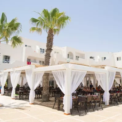Terrasse extérieure du restaurant de l'hôtel Seabel Aladin à Djerba, style architectural tunisien.