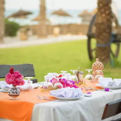 Table de restaurant vue mer avec décoration florale à l'hôtel Seabel Aladin, Tunisie.