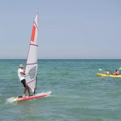 Activités nautiques incluant planche à voile et kayak de mer sur la plage privée du Seabel Aladin Djerba.