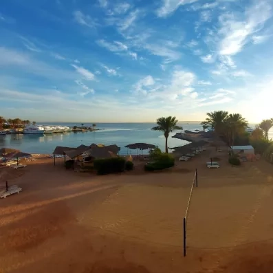 plage sable fin, terrain de beach volley, transats, parasol, yacht au quai 