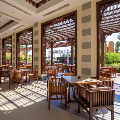 Terrasse ensoleillée du restaurant Stella Beach à Hurghada, Égypte, avec mobilier en bois et architecture orientale.