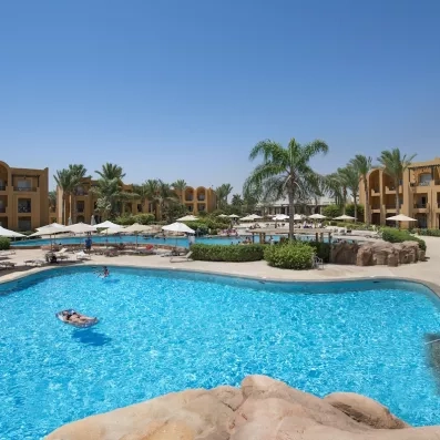 Grande piscine lagon bleue avec complexes hôteliers et palmiers au Stella Beach Resort d'Hurghada en Égypte.