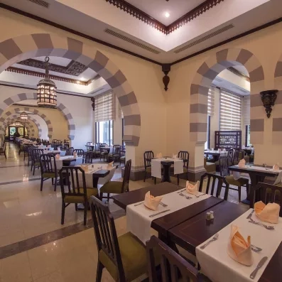 Salle de restaurant élégante avec arches orientales au Stella Beach, destination culturelle et gastronomique à Hurghada.
