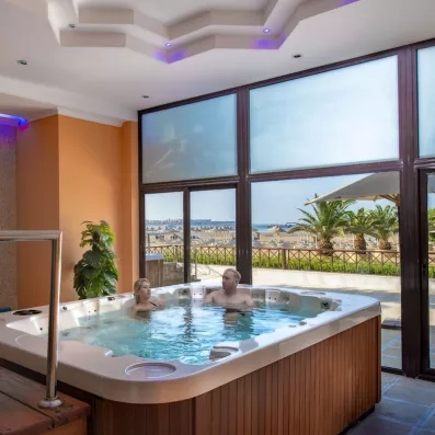 Couple se relaxant dans un jacuzzi avec vue sur la mer, espace bien-être du Stella Beach Égypte.