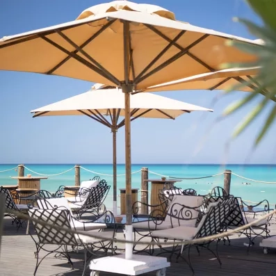 Salon de jardin avec parasols et vue sur la mer 