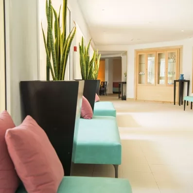 Couloir aménagé avec des canapés bleus garnis de coussins roses