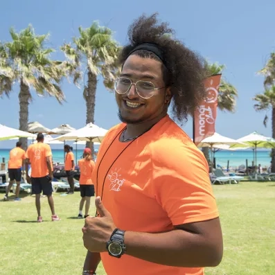 animateur souriant représentant mondial tourisme, vêtu d'un t-shirt orange 
