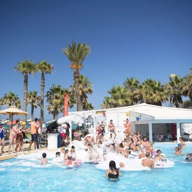 Mousse party dans la piscine extérieure avec plusieurs enfants qui s'amusent 