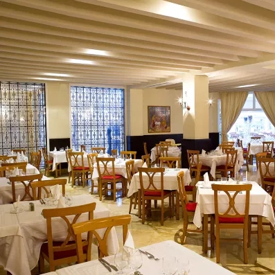 salle de restaurant typique tunisienne avec plusieurs tables dressées 