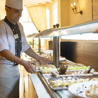 cuisinier disposant des plats sur le buffet 