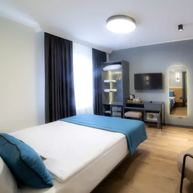 chambre avec un lit double et une télévision murale et un dressing