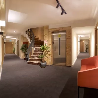 couloir de l'hôtel avec un canapé et un escaliers ainsi qu'un ascenseur