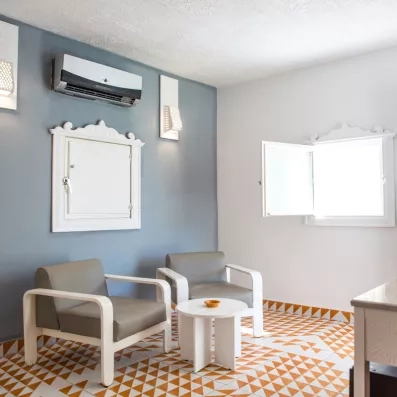 Salon de bungalow avec fauteuils design et sol en carrelage géométrique au Mondi Club Shems Monastir.