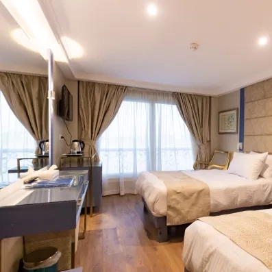 Cabine spacieuse avec lits jumeaux et vue sur le fleuve, confort d'une croisière sur le Nil.