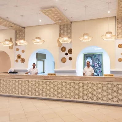Comptoir de réception lumineux et spacieux de l'hôtel Mondi Club Shems à Monastir au design typique.