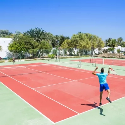 Joueurs de tennis en action sur un court extérieur ensoleillé au Mondi Club Shems à Monastir.