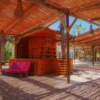 Bar extérieur en bois et paillote EcoBar pour se rafraîchir à l'ombre des palmiers à Djerba.