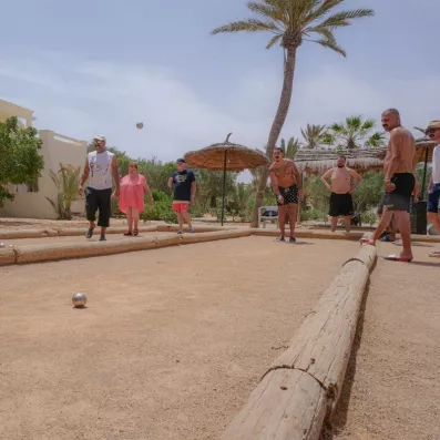 Session de pétanque sous les palmiers entre voyageurs lors d'un séjour détente au Djerba Aqua Resort.